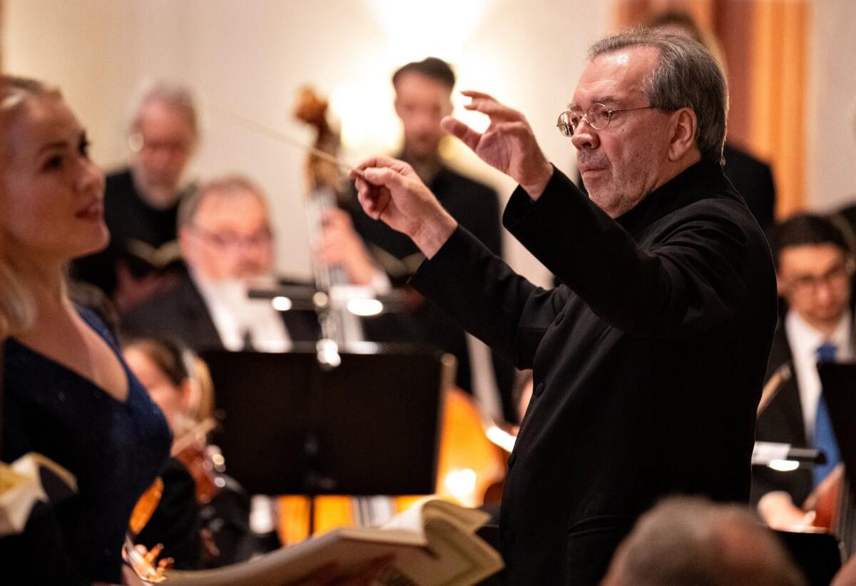Man sieht den Chorleiter Christian Kabitz beim Dirigieren des Orchesters und des Chores
